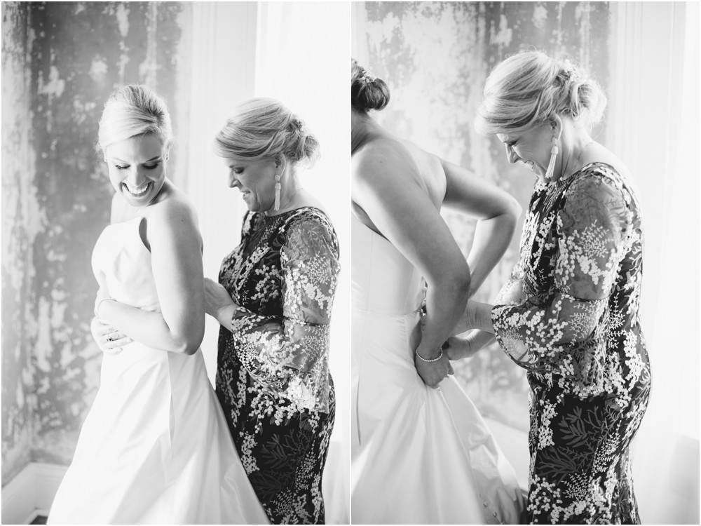 mother of the bride helping daughter into dress